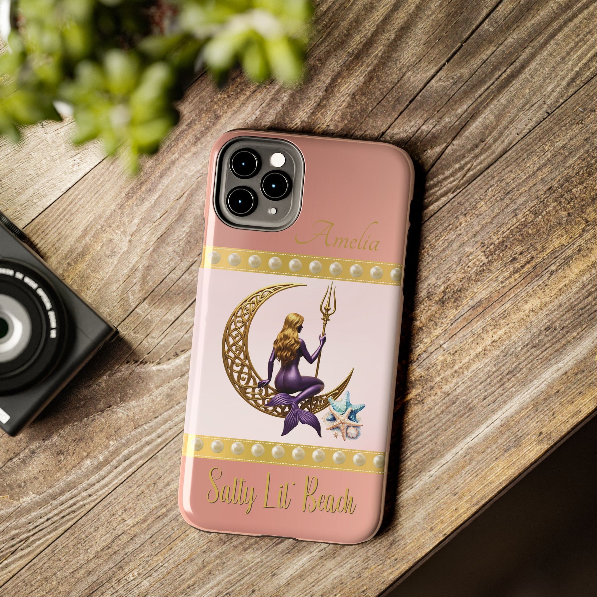 Phone case with mermaid design on a wooden surface