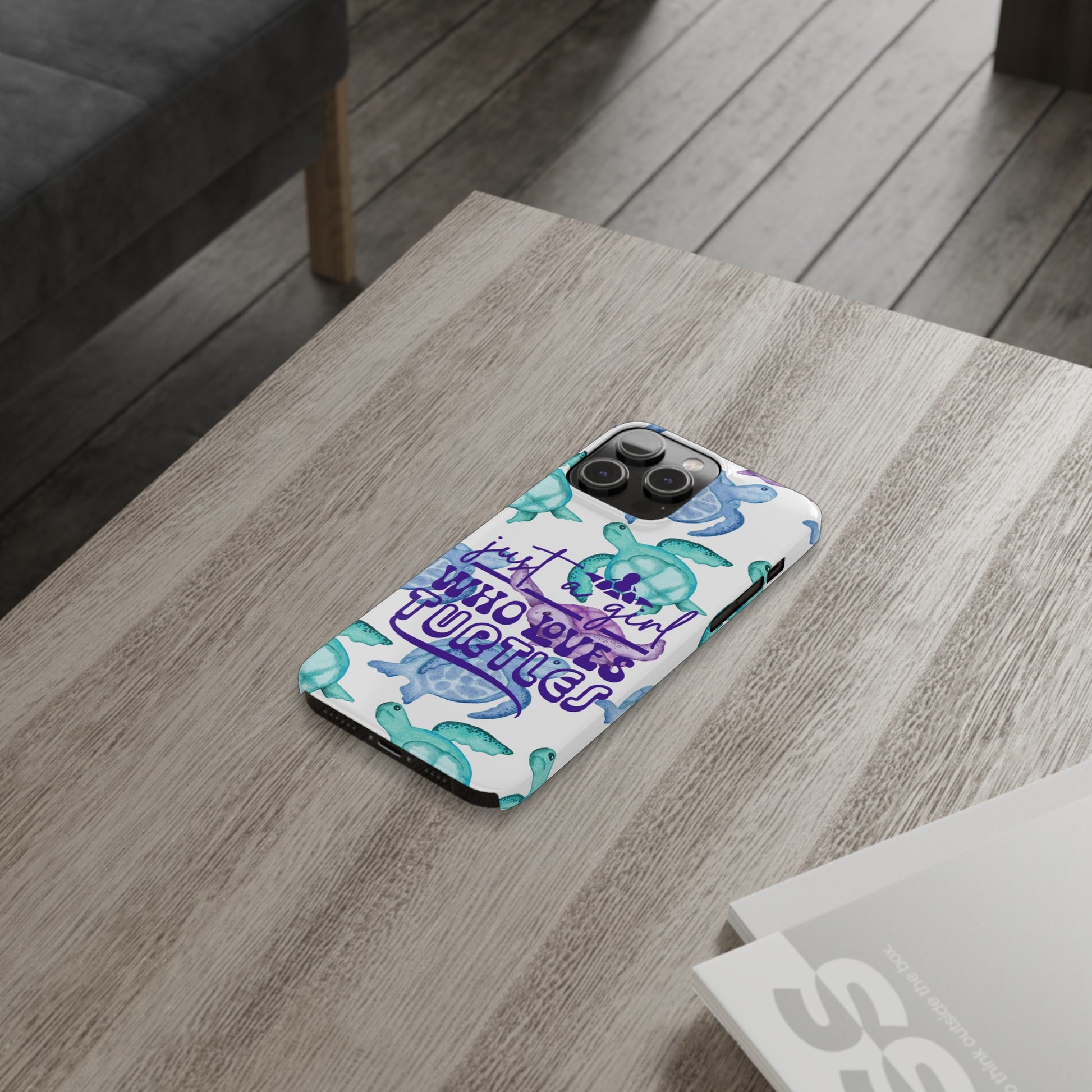 Iphone case with turquoise, blue and purple sea turtles that says  Just a Girl Who Loves Sea turtles laying on table