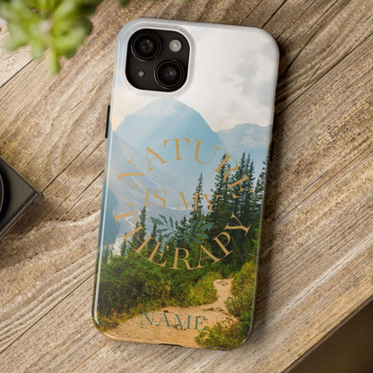 Phone case with nature design and 'Nature is my therapy' text on a wooden surface