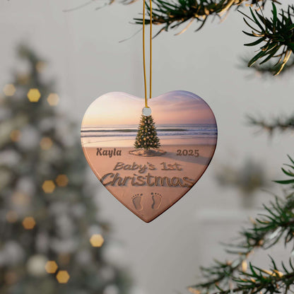 Heart-shaped ornament with a beach scene and engraved text, hanging on a tree.