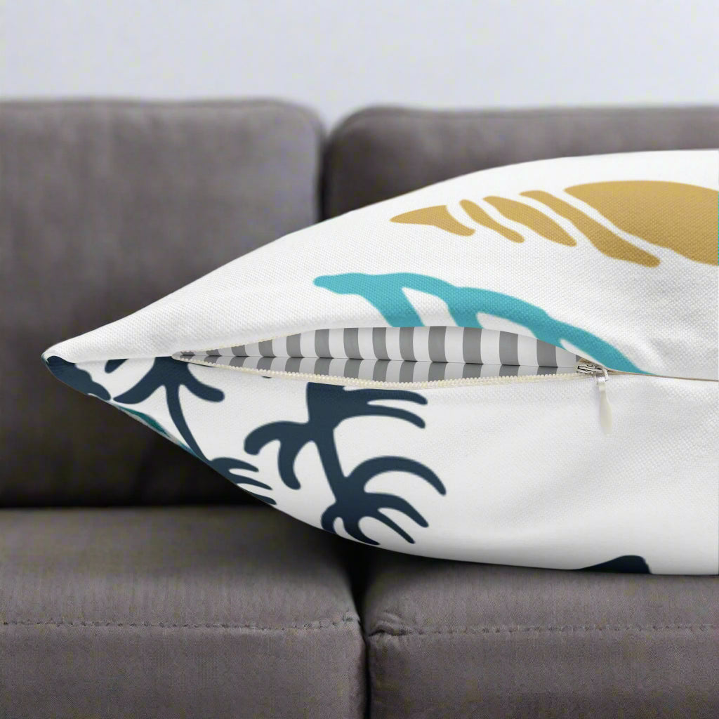 Decorative white pillow with blue and gold shells and starfish.  