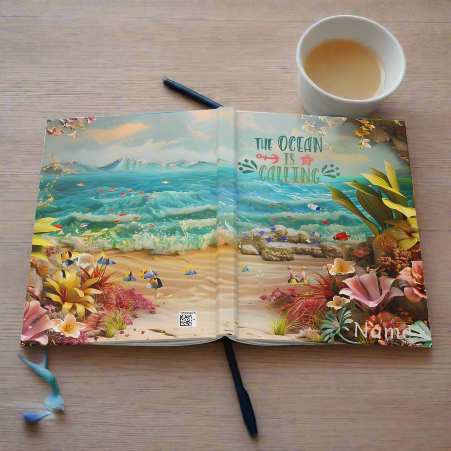 Opened a hardcover journal laying open to show front and back with an ocean scene with flowers and the text the ocean is calling