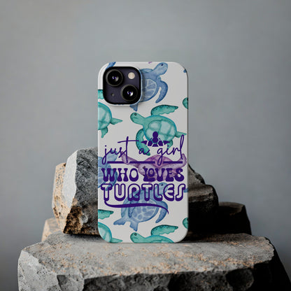 Iphone case with turquoise, blue and purple sea turtles that says  Just a Girl Who Loves Sea turtles laying against rock