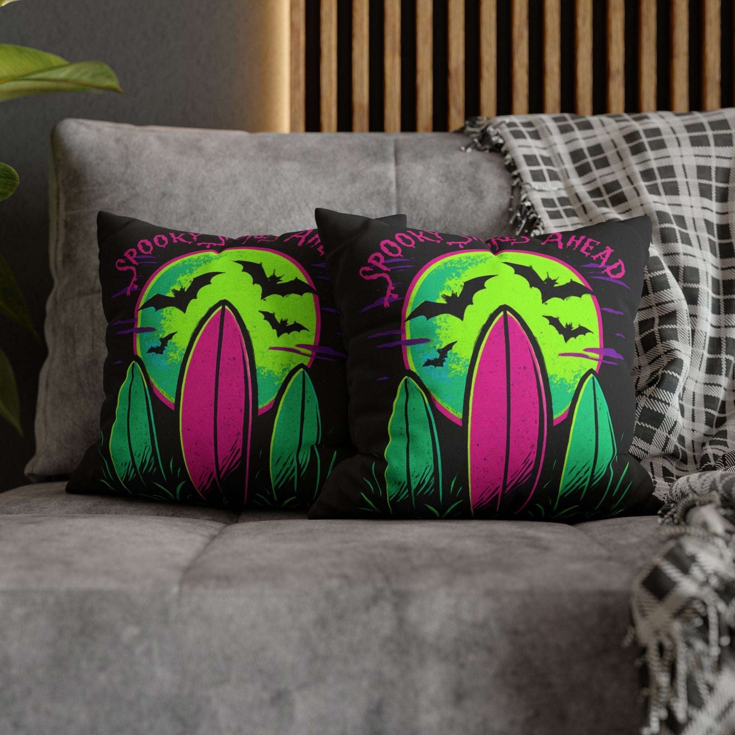 Decorative pillows with Halloween-themed designs on a gray couch.