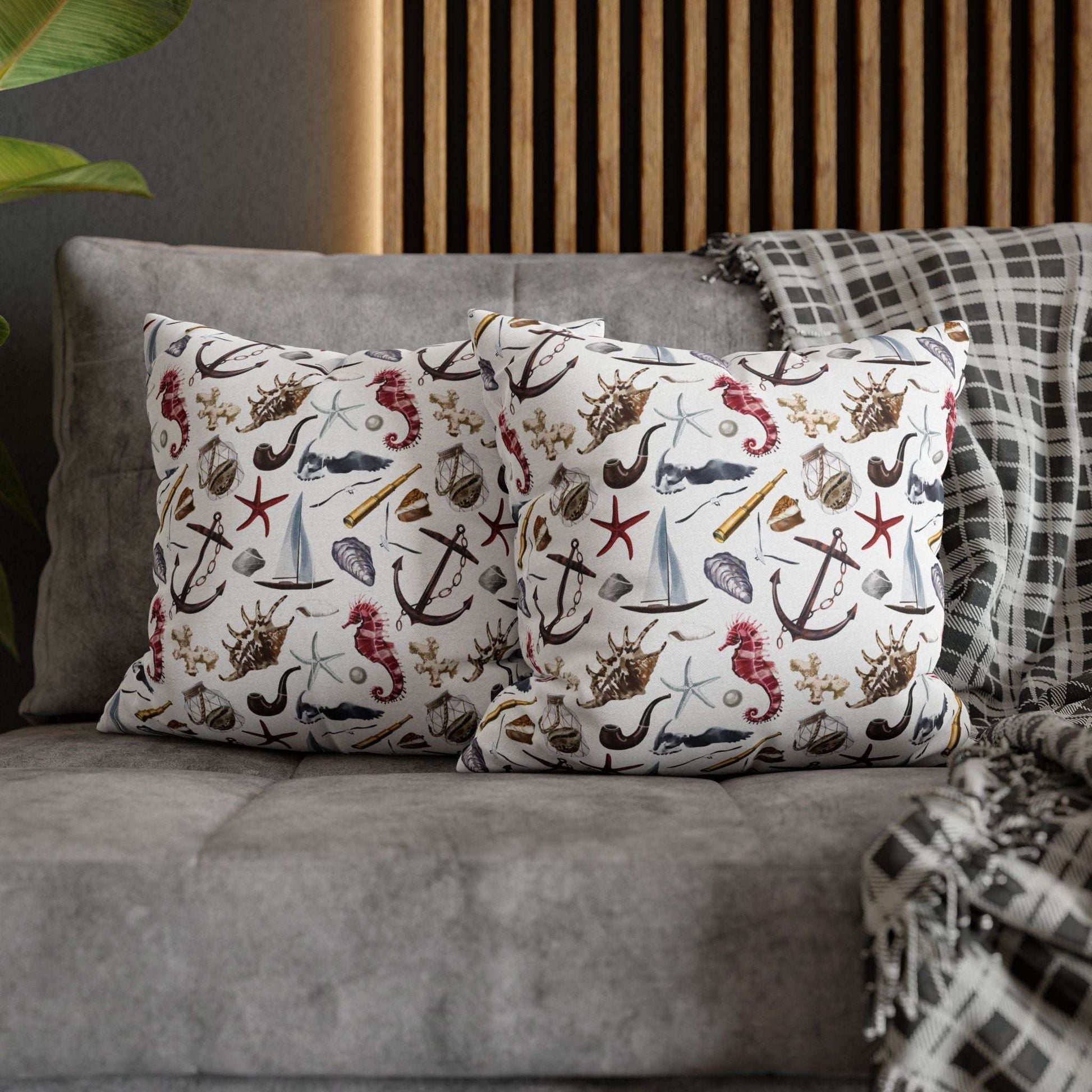 Two 16" x 16" white pillowcases featuring detailed graphics of anchors, seashells, sailboats, and seahorses in a nautical-themed pattern.