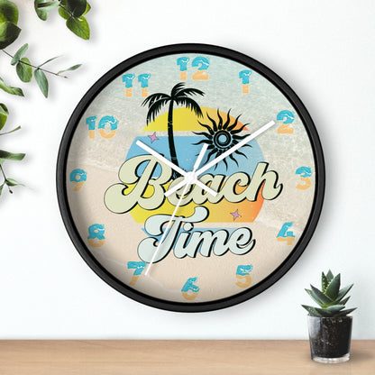 A circle wall clock with a black frame with white handles with an image of palm trees and sunset with a background of ocean water and sand that says Beach Time.