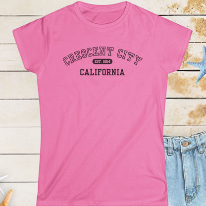Pink t-shirt with 'Crescent City, California' text on a wooden surface with starfish.