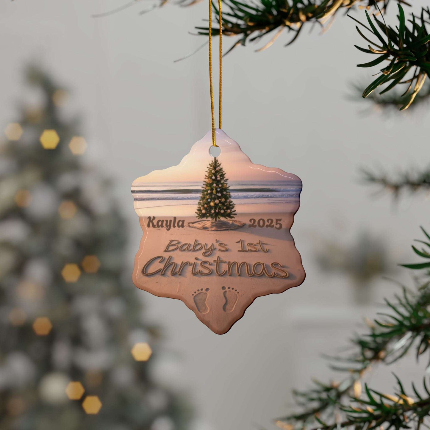 Decorative ornament for 'Kayla's Baby's 1st Christmas' hanging on a tree branch with a blurred festive background.