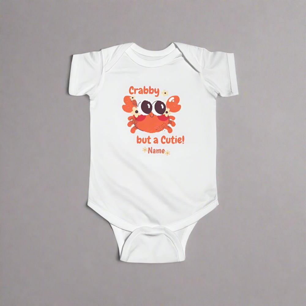 White short-sleeved bodysuit with cartoon crab that says crabby but a cutie with a space for a personalized name below.