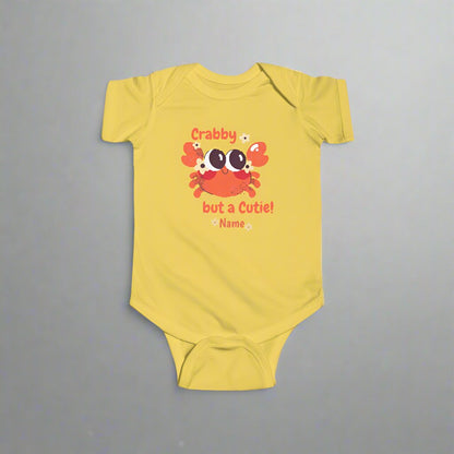 Yellow short-sleeved bodysuit with cartoon crab that says crabby but a cutie with a space for a personalized name below.