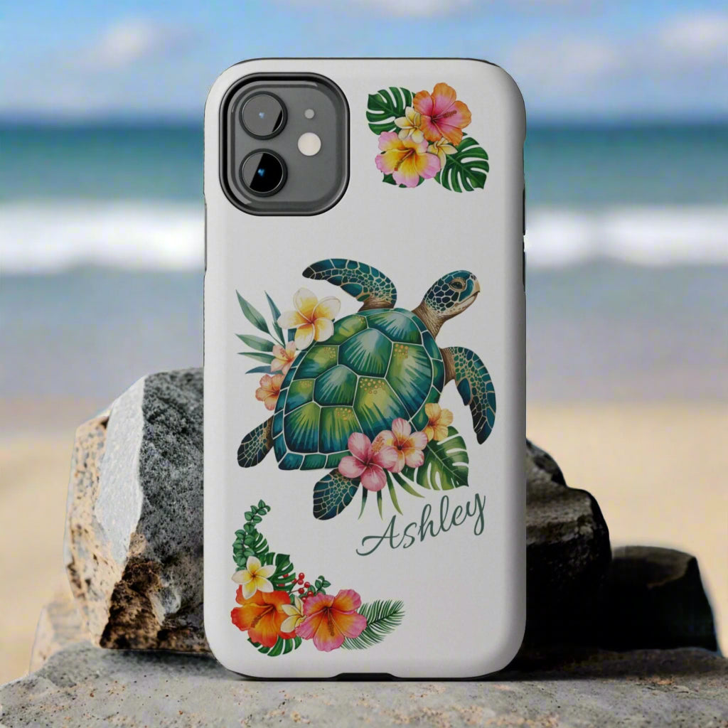 iPhone 13 case with a white background and a sea turtle with hibiscus flowers, with more hibiscus flowers around the sides.
