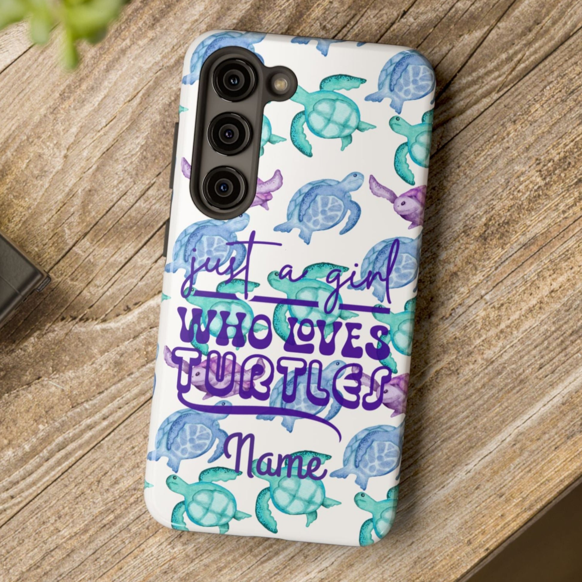 Phone case with sea turtle design and text on a wooden surface