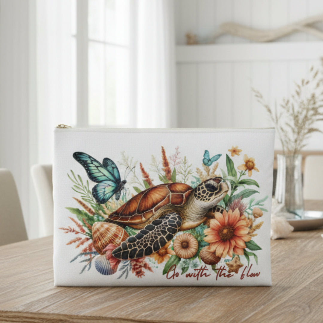 Pouch with a turtle, butterfly, and floral design on a white background