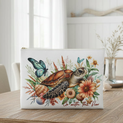 Pouch with a turtle, butterfly, and floral design on a white background