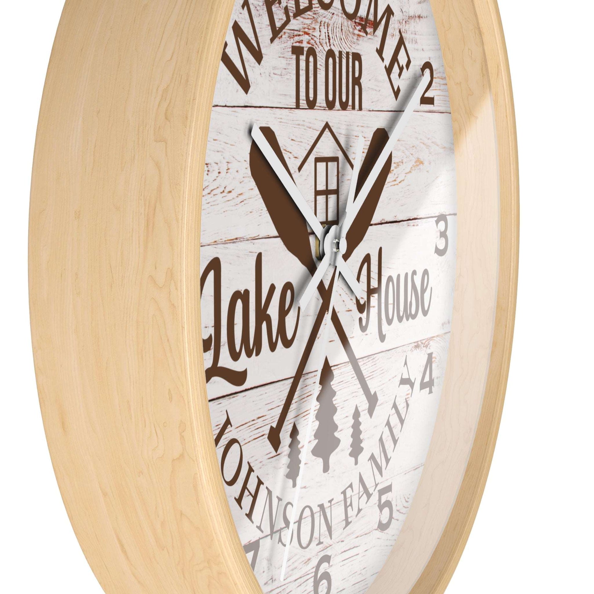 Wall clock with 'Welcome to our Lake House' text and wooden design on a white background