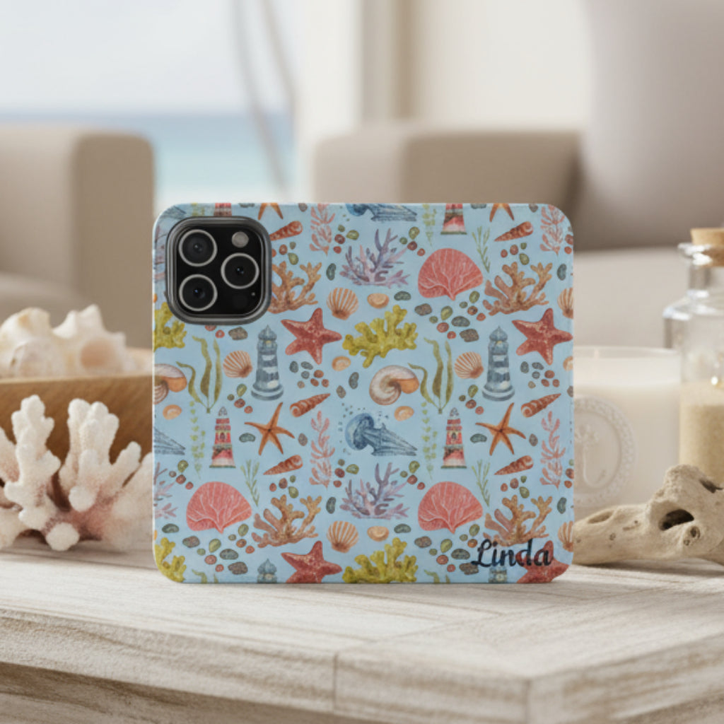 Opened flip phone case with a watercolor pattern featuring lighthouses, seashells, coral, and starfish, customizable with a name.