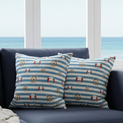 Two decorative pillows with nautical patterns on a gray sofa.