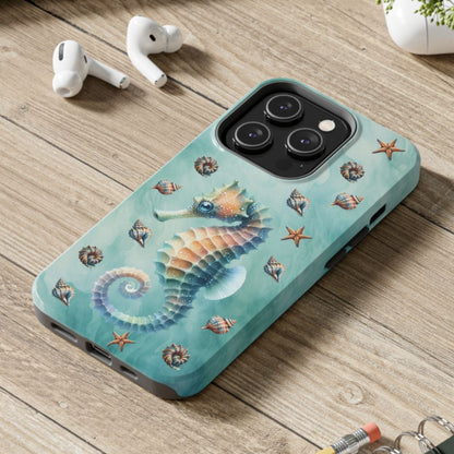 Phone case with seahorse design on a wooden surface with laptop, earbuds, and notebook.