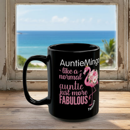 Black mug with pink flamingo design and text on a white background