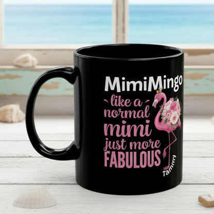 Black mug with pink flamingo design and text on a white background