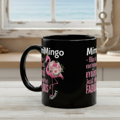 Black mug with pink flamingo design and text on a white background