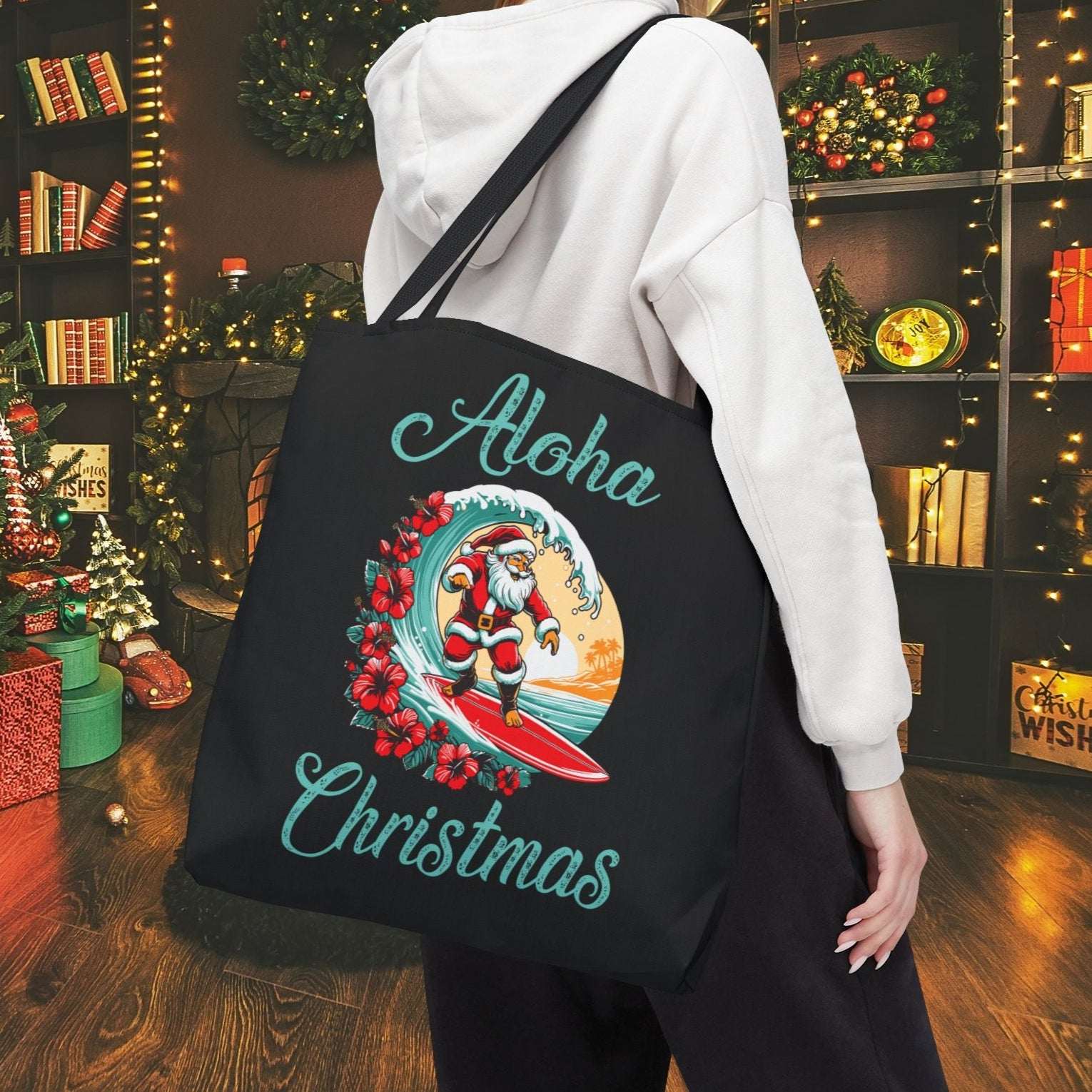 Person wearing a black tote bag with 'Aloha Christmas' design in a festive room.