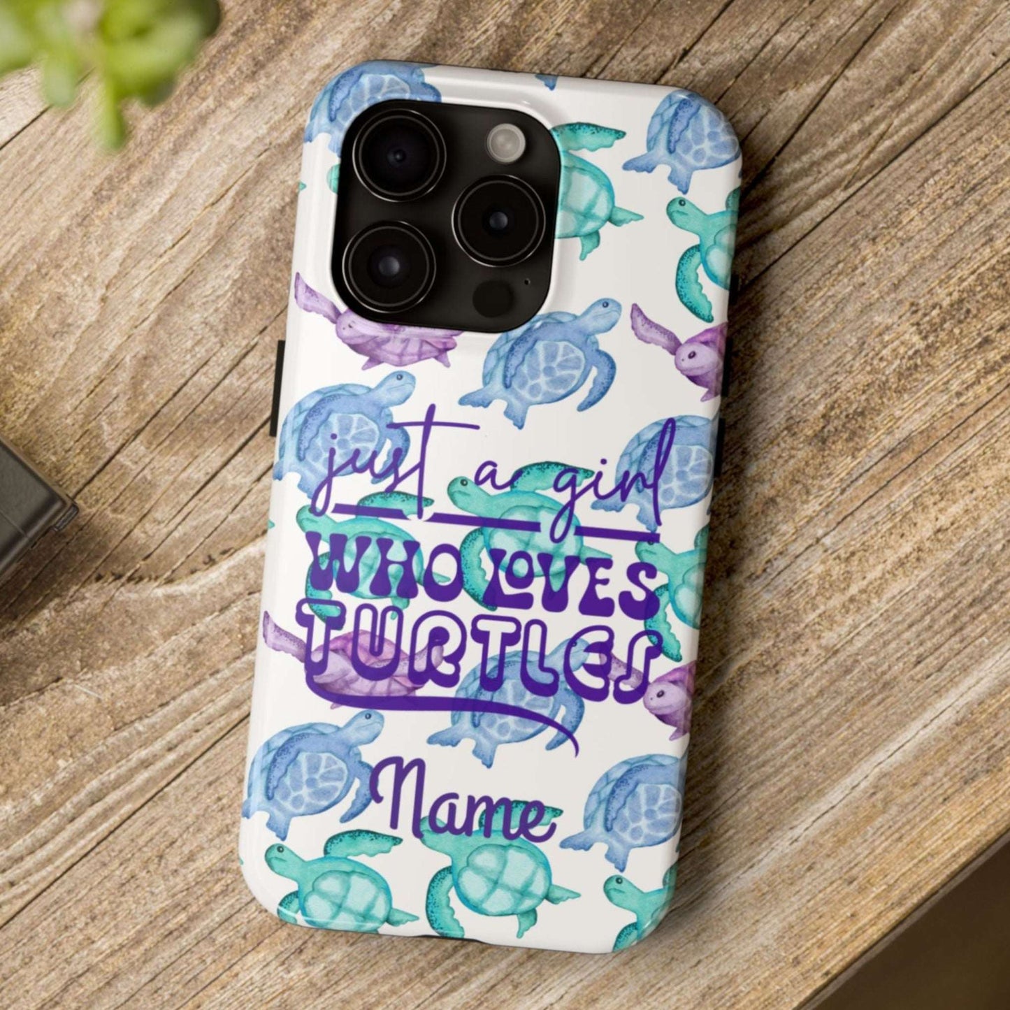 Phone case with sea turtle design and text on a wooden surface