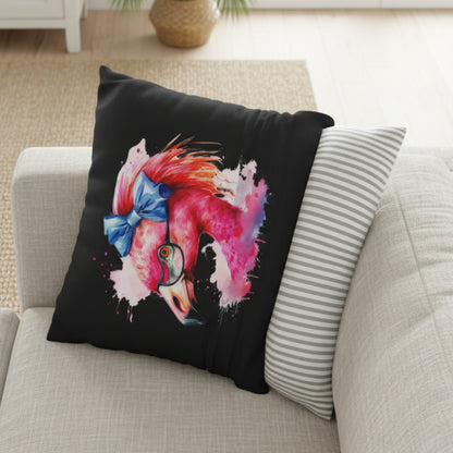 Decorative pillow with a colorful flamingo design on black fabric and a striped pillow next to it.