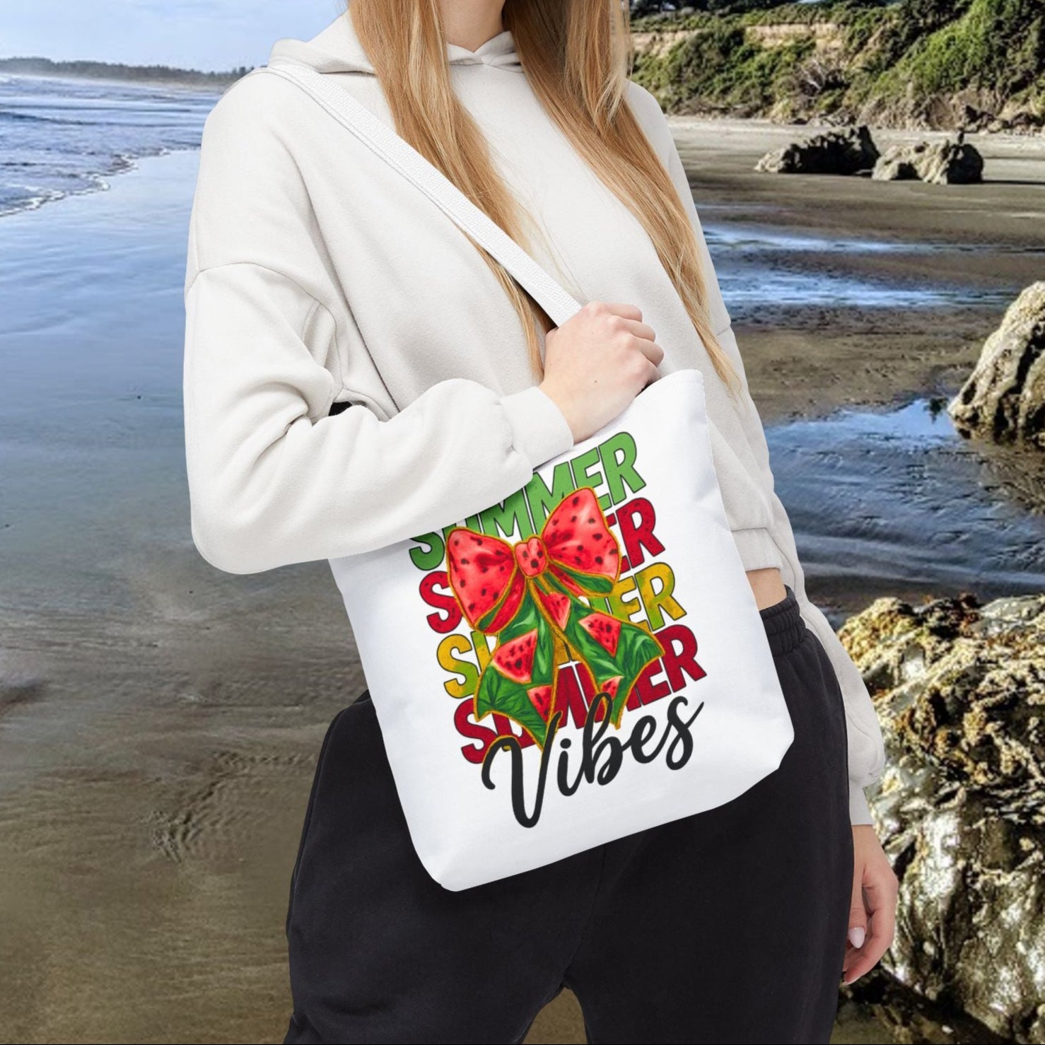 White 13" x 13" tote bag with the word "Summer" repeated in green, red, and yellow, featuring a coquette-style bow, watermelon illustrations, and the word "Vibes" underneath.