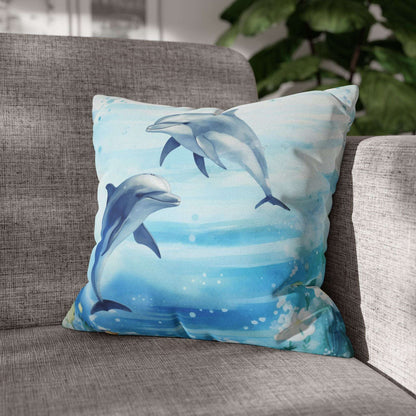 Pillow cover with a watercolor design of two dolphins in the water with flowers along the bottom edges.