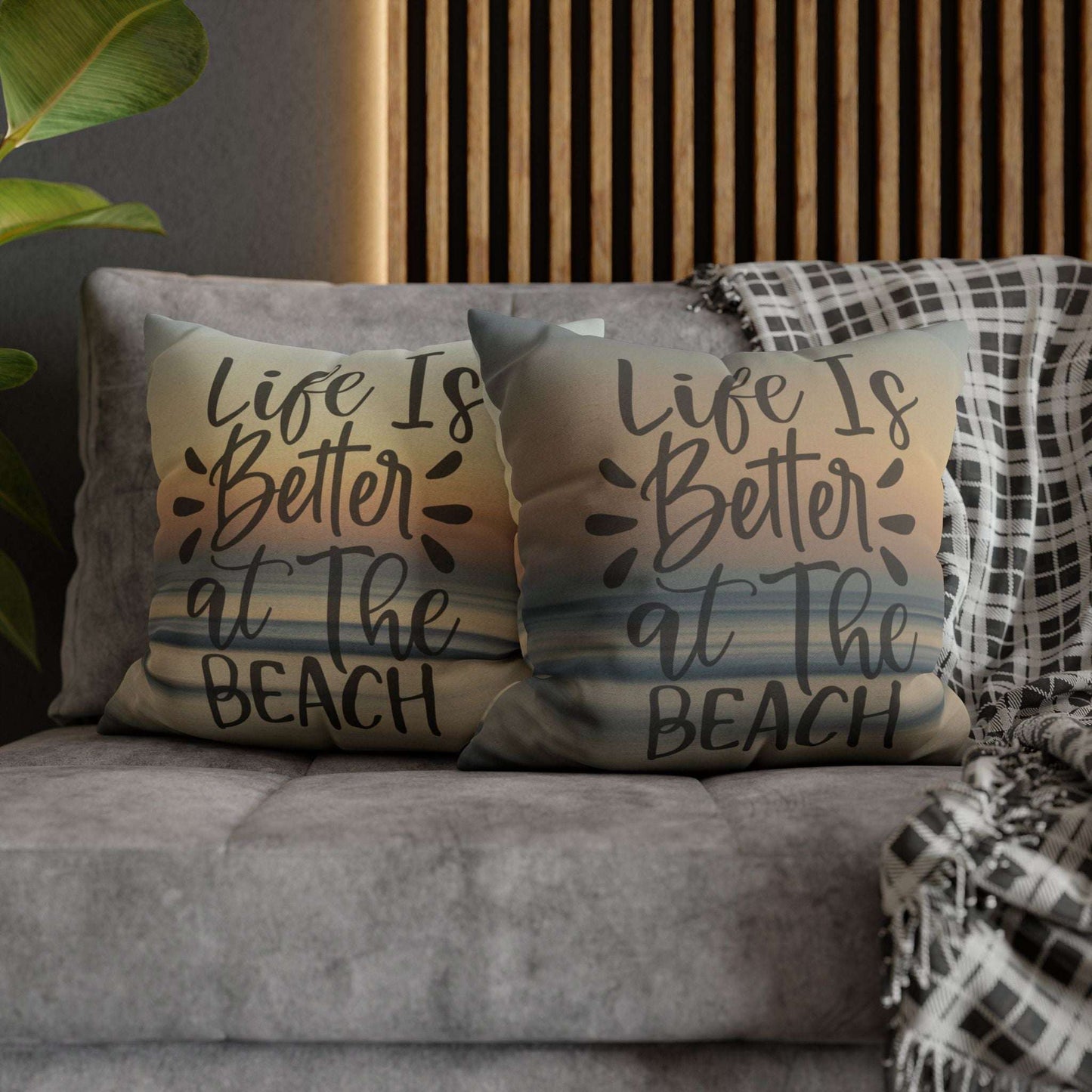 Two pillow cases with 'Life is Better at the Beach' text on a couch.