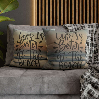 Two pillow cases with 'Life is Better at the Beach' text on a couch.