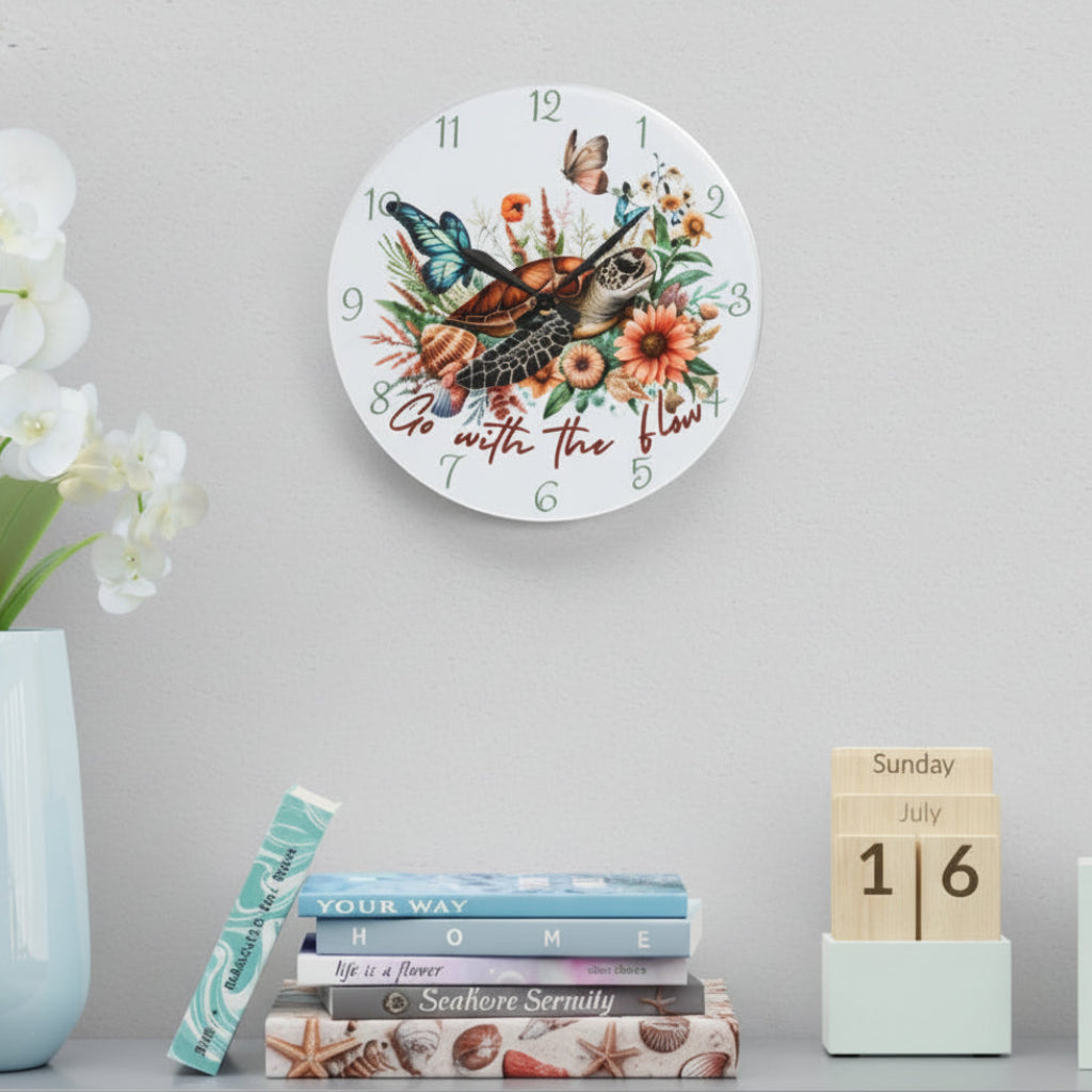 Decorative wall clock with floral and sea turtle design, placed on a shelf with books and a vase.