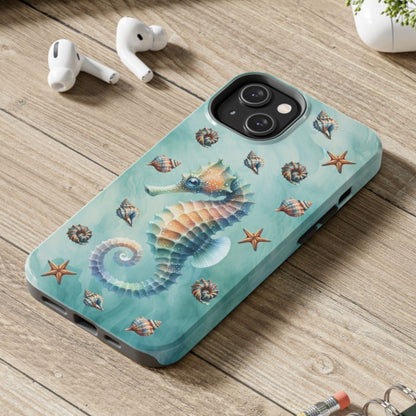 Phone case with seahorse design on a wooden surface with laptop, earbuds, and notebook.