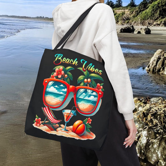 Black 18" x 18" Tote bag featuring sunglasses with ocean and beach scene reflections, palm trees coming out of the glasses, a beach chair and cocktail on the sand, with the phrase "Beach Vibes" in a retro rainbow gradient font.