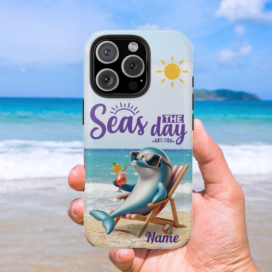 Seas the Day dolphin-themed phone case with personalized name, glossy finish, and beach-inspired design with a dolphin enjoying a cocktail during a sunny day on the beach with the phrase Seas the Day. 