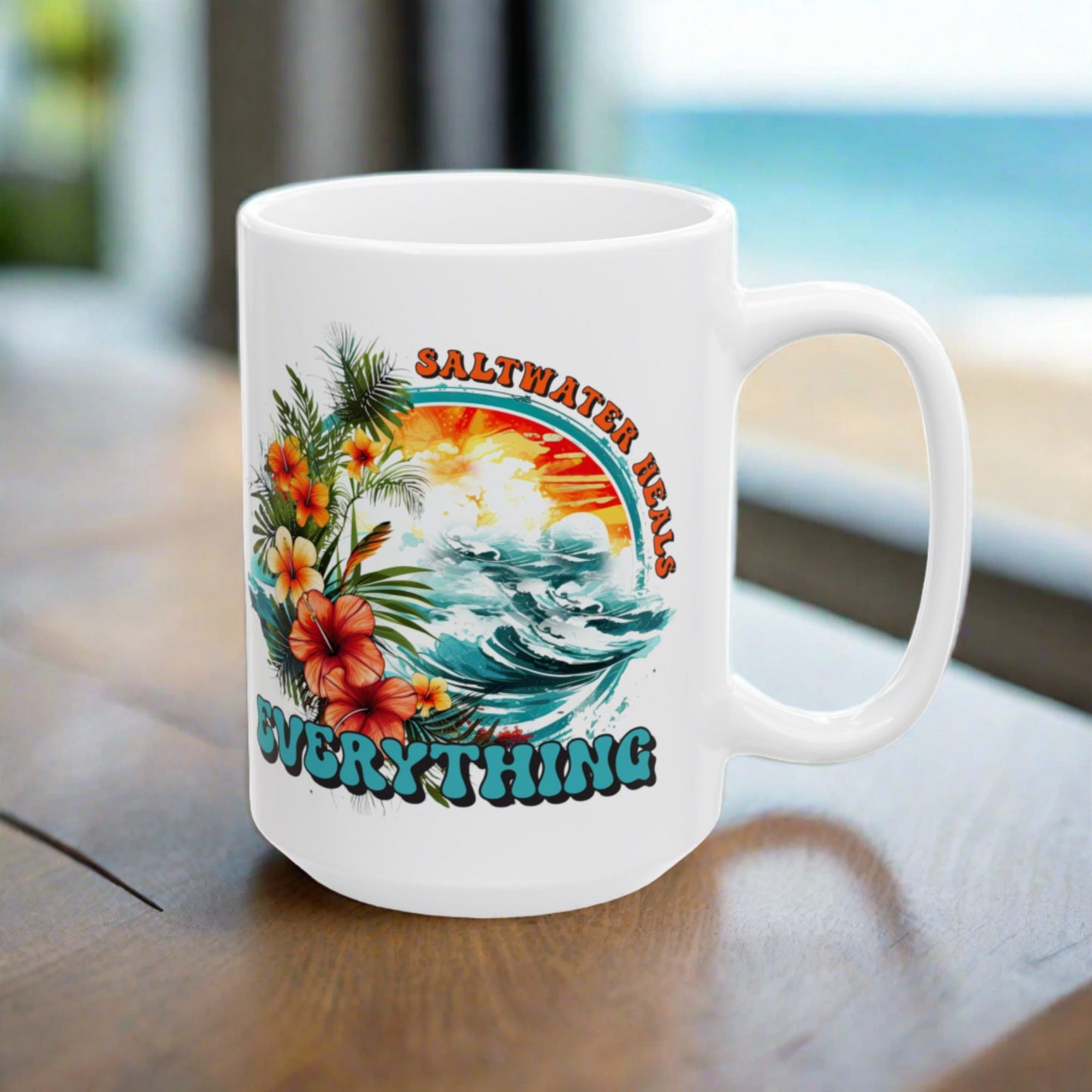 White mug with a colorful design featuring hibiscus flowers and ocean and text that says Saltwater Heals Everything on a wooden surface.