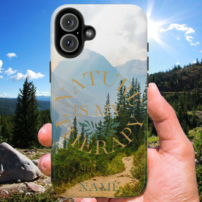 Phone case with 'Nature is my therapy' text held in front of a scenic mountain landscape.