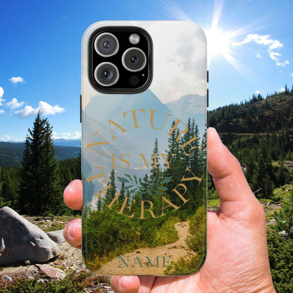 Phone case with nature design held in front of a scenic mountain landscape