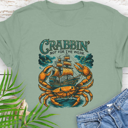 Green t-shirt with a large crab enveloping a pirate ship with the text “Crabbin’s Not for the Weak” in an old-style font.