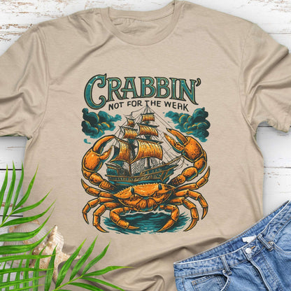 Beige t-shirt with a large crab enveloping a pirate ship with the text “Crabbin’s Not for the Weak” in an old-style font.