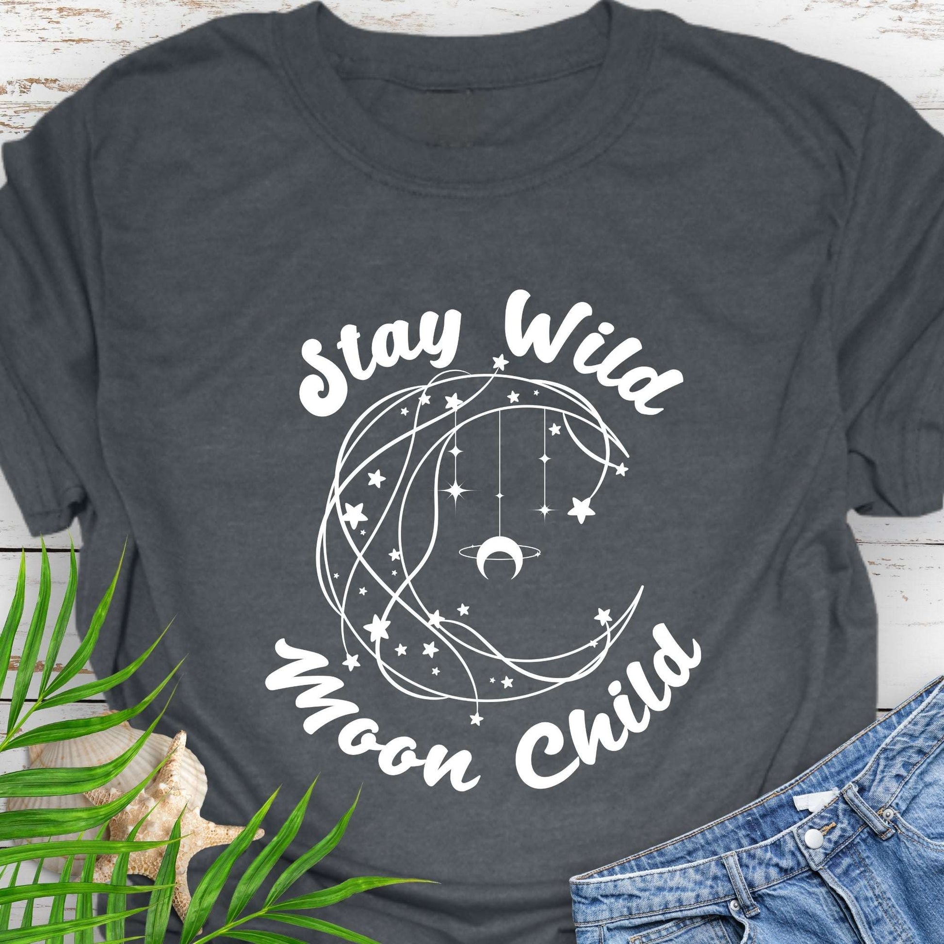 Dark gray T-shirt with crescent shaped lines and hanging crescent moon and stars that says Stay Wild Moon Child.
