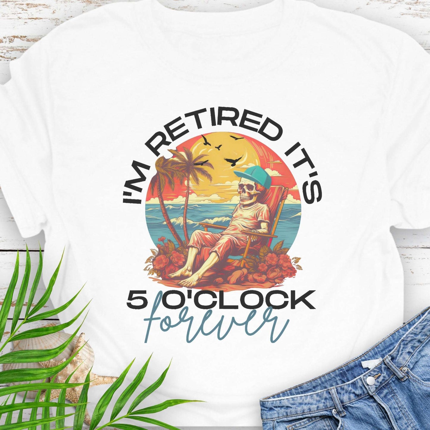 White t-shirt with a skeleton lounging on beach with text 'I'm Retired It's 5 0'Clock Forever.