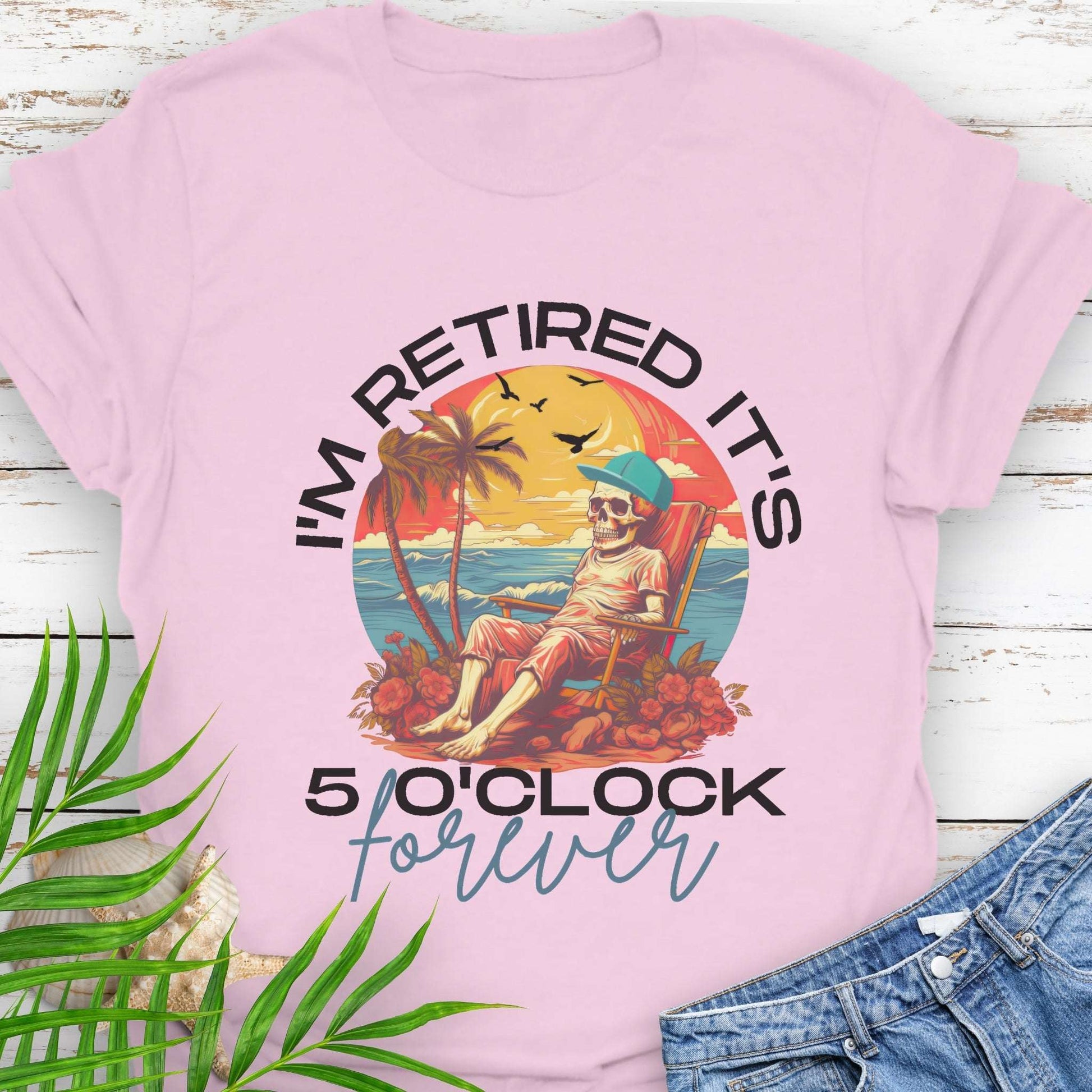 Pink t-shirt with a skeleton lounging on beach with text 'I'm Retired It's 5 0'Clock Forever.