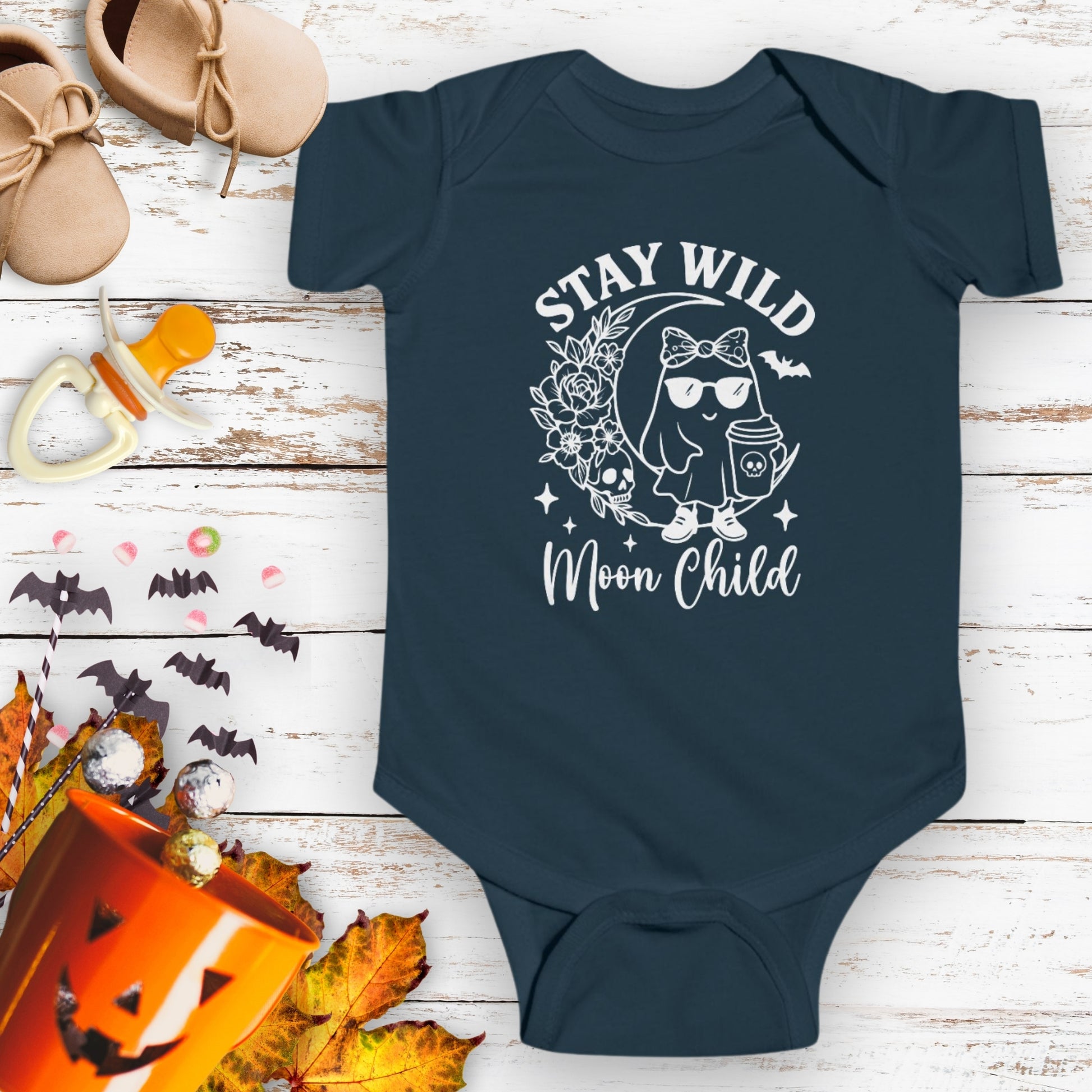 Navy blue infant bodysuit featuring a girl ghost sitting on a crescent moon with floral accents and a skull design, with the text “Stay Wild Moon Child.”