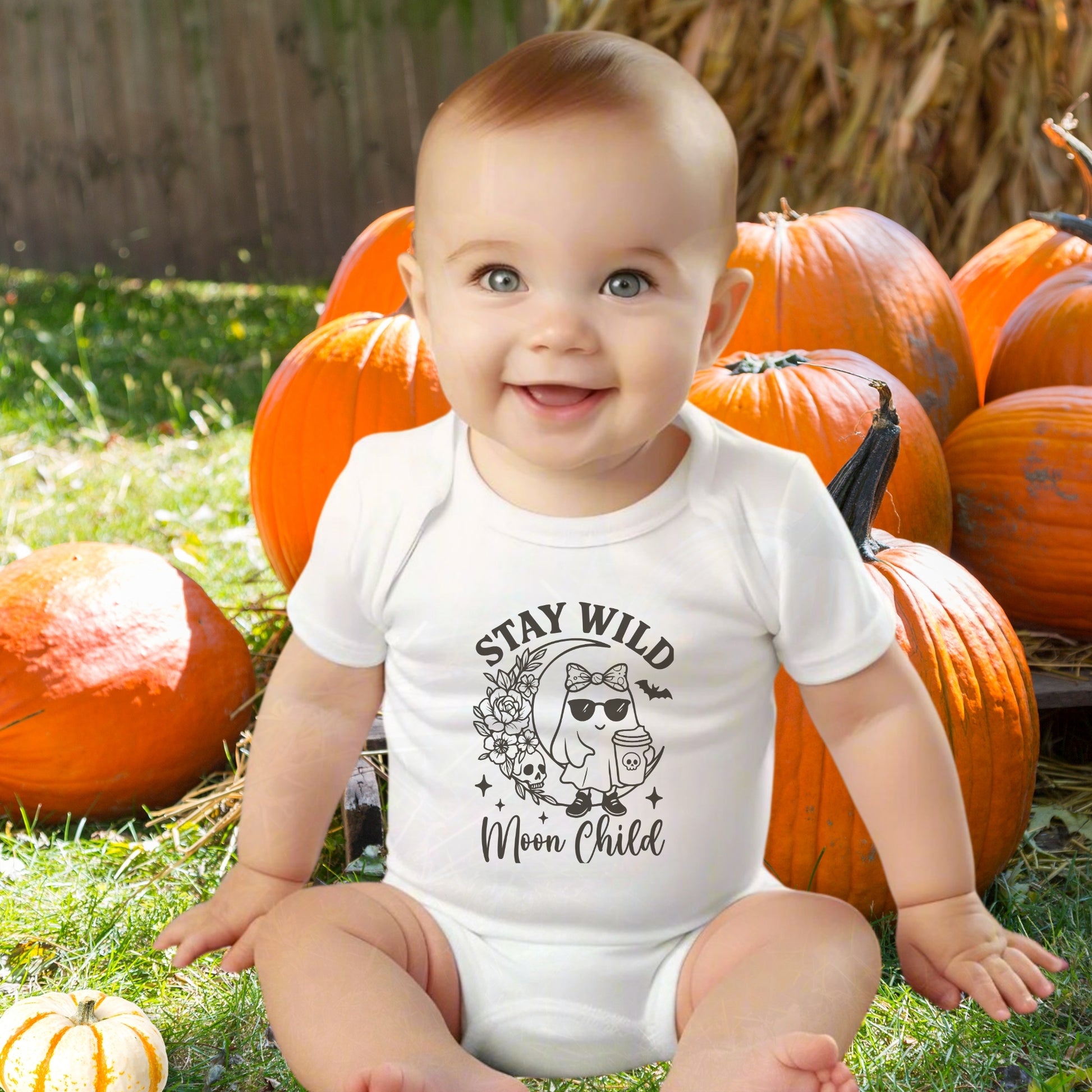 Baby wearing a white infant bodysuit featuring a girl ghost sitting on a crescent moon with floral accents and a skull design, with the text “Stay Wild Moon Child.”