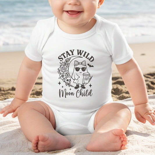 Baby wearing a white infant bodysuit featuring a girl ghost sitting on a crescent moon with floral accents and a skull design, with the text “Stay Wild Moon Child.”