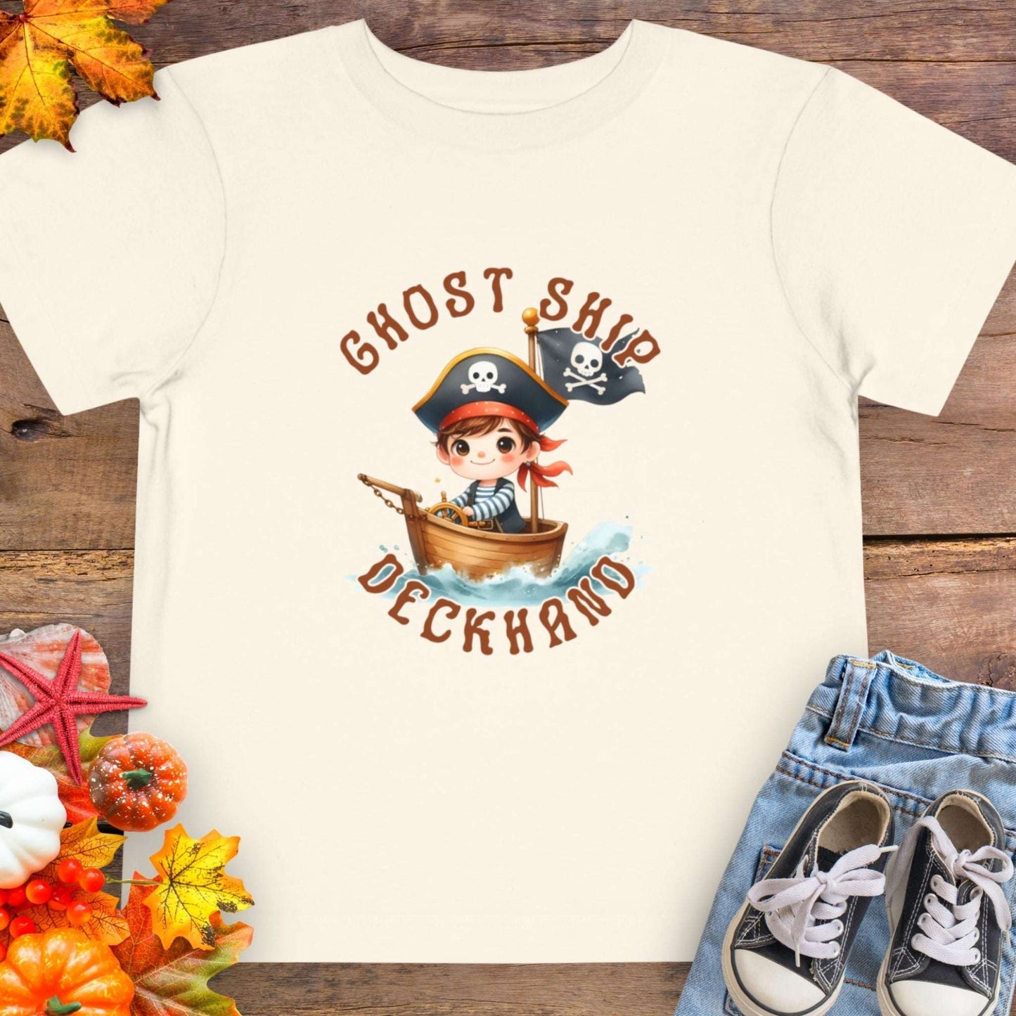 Light Beige t-shirt with a cartoon pirate boy in a boat with text 'Ghost Ship Deckhand'. 