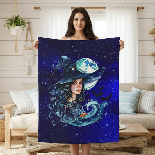 Woman holding a blanket with a witch design in a living room.