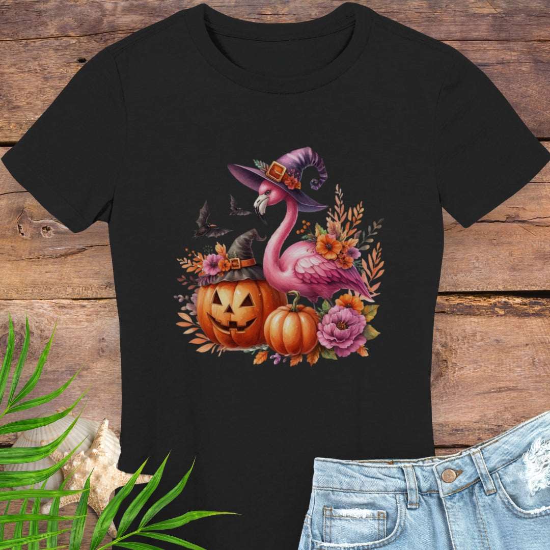 Black t-shirt with a flamingo wearing a witch hat and surrounded by pumpkins and flowers.